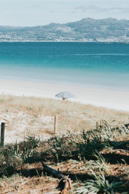 beach-with-aqua-blue-water-and-a-single-beach-umbrella.png